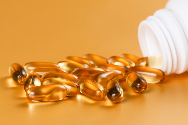 Many capsules Omega 3 on yellow