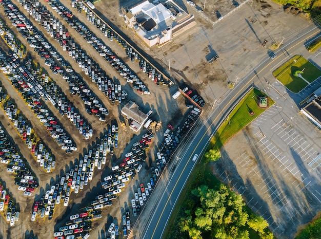 Многие припаркованные автомобили распределены на аукционе подержанных автомобилей.