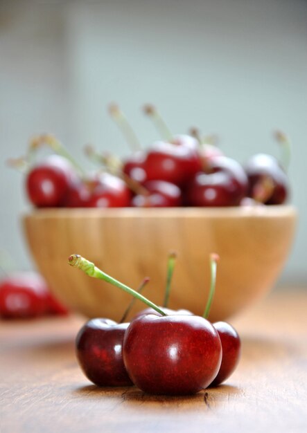 Many cherries in a wooden bowl on a table