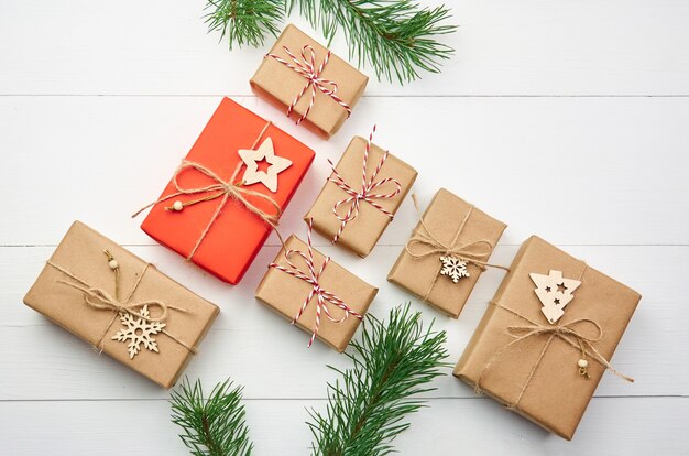 Many christmas gift boxes with pine tree branches on white