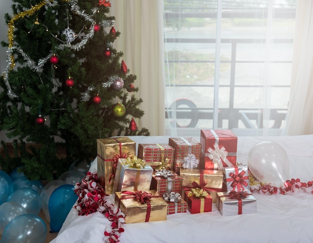 많은 크리스마스는 크리스마스 트리, 휴일, 선물, 새해 및 축하 컨셉으로 테이블에 선물 상자를 선물합니다.