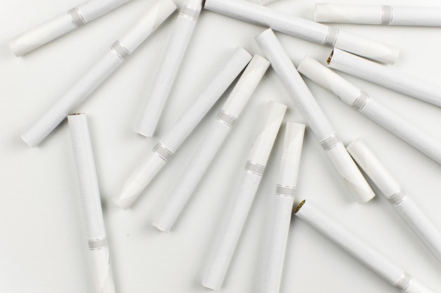Многие сигареты лежат на светлом фоне