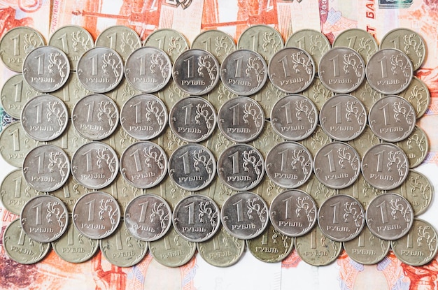 Photo many coins of 1 ruble lie on russian money