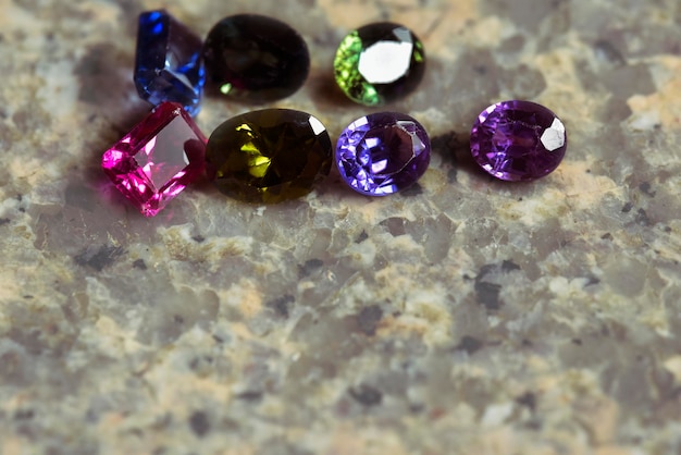 Many color of gemstones on granite backdrop.old gem