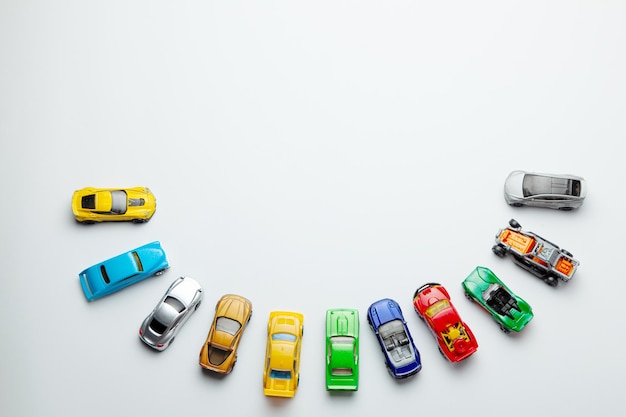 Many colored little toy cars on a gray background.