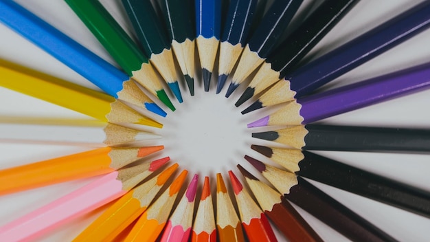 Many colored pencils are arranged around the edges of the image