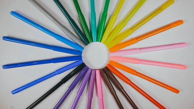 Many colored pencils are arranged around the edges of the image