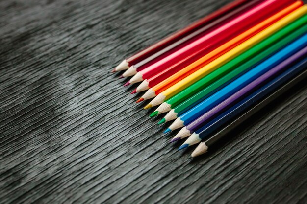 Many colored pencils on a black background. New pencils