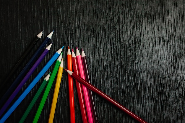 黒の背景に多くの色鉛筆。新しい鉛筆
