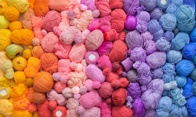 Many colorful balls of wool and cotton yarns