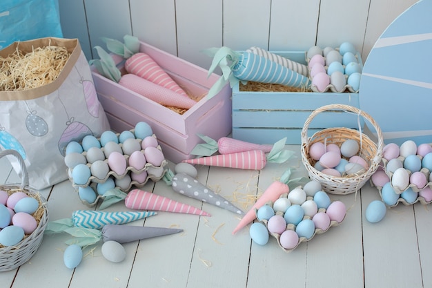 Many colorful Easter eggs and baskets of carrots on wooden floor Easter room decoration