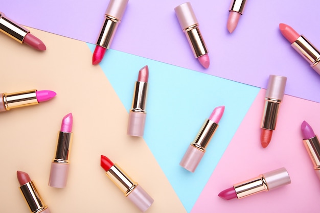 Many colorful lipstick on colorful, flat lay