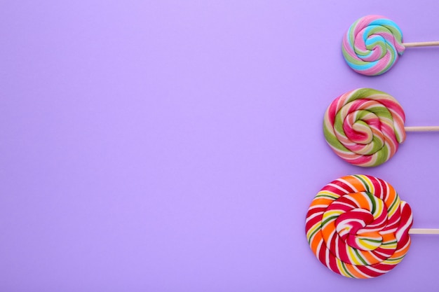 Many colorful lollipops on purple background, Sweets