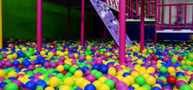 Many colorful plastic balls in a kids' ballpit at a playground