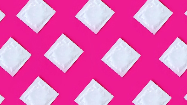 many condoms in rows on pink background, collection, composition of condoms