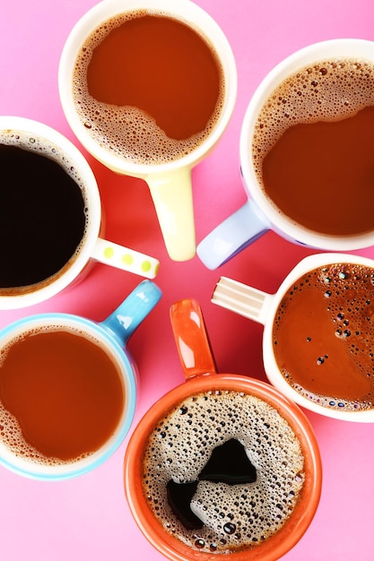 Many cups of coffee on pink background