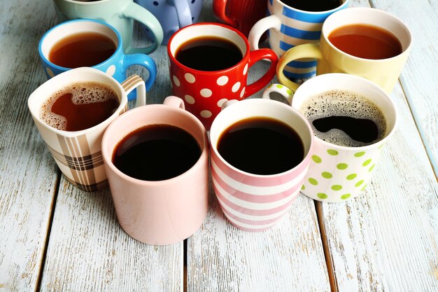 Many cups of coffee on wooden table closeup