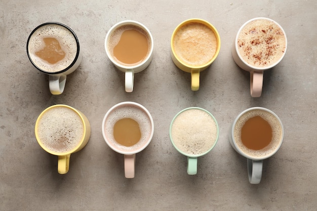 Photo many cups with different aromatic coffee on light grey table flat lay