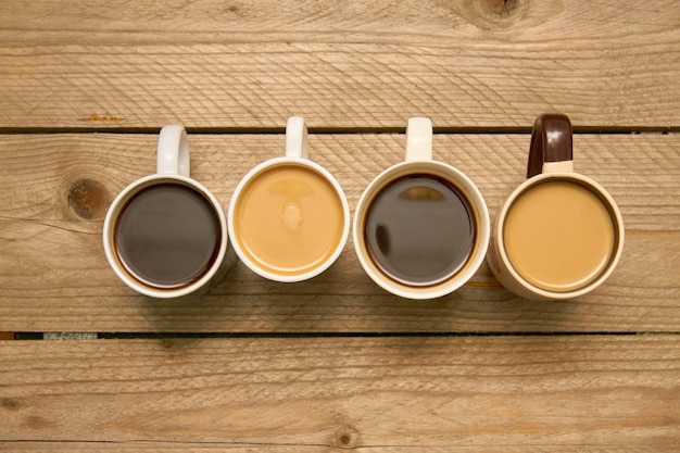 Many cups with tasty aromatic coffee on wooden table Top view with copy space