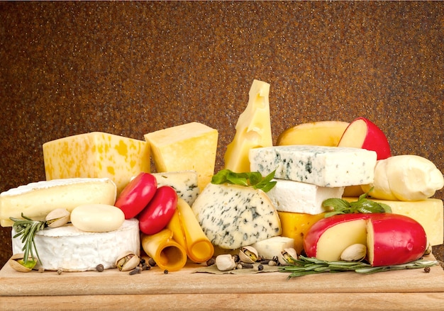 Many delicious aged cheeses on wooden plate