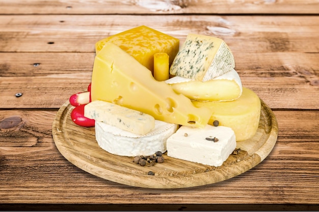 Many delicious aged cheeses on wooden plate