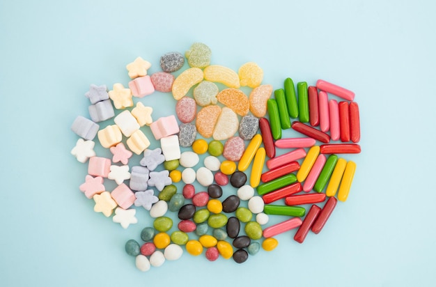 Many different candies sweets on blue background