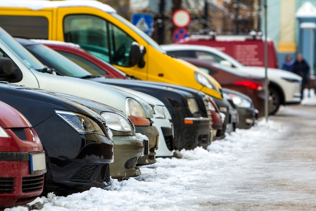 Many different cars parked in a city. Cars for sale