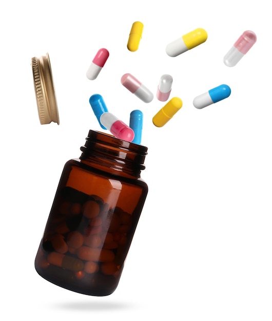 Photo many different colorful pills falling into bottle on white background