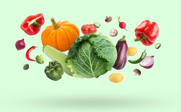 淡い明るい緑の背景に落ちる様々な新鮮な野菜