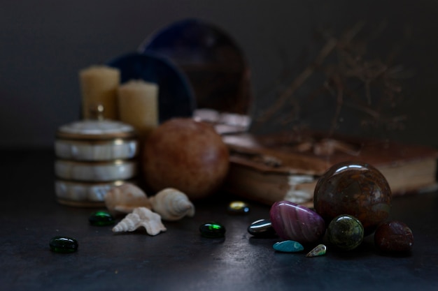 Many different gemstones on the blurred mirrors and  candles background.