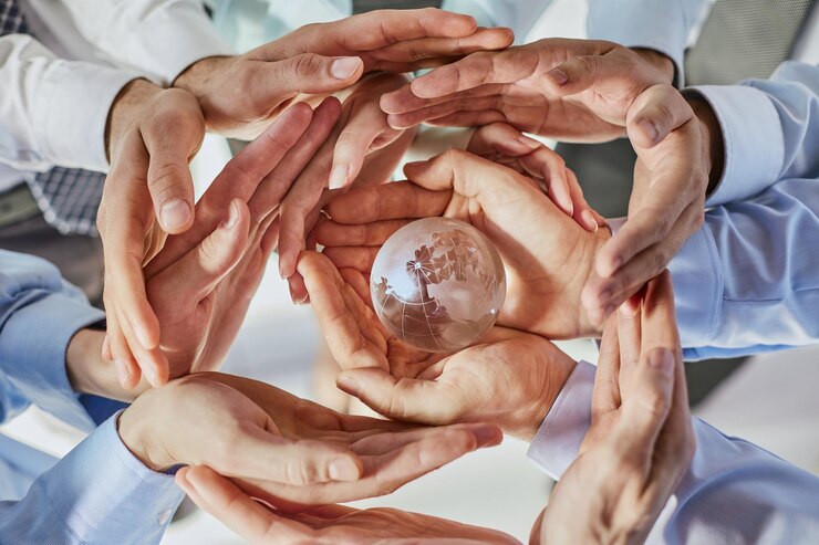 Photo many different hands are holding planet earth