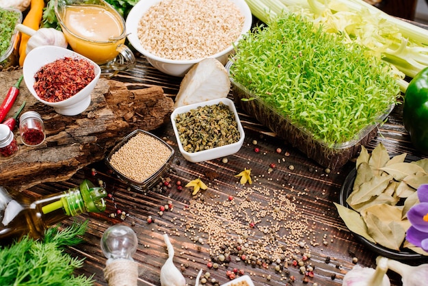 Many different herbs and spices raw and dry with vegetables on wooden background