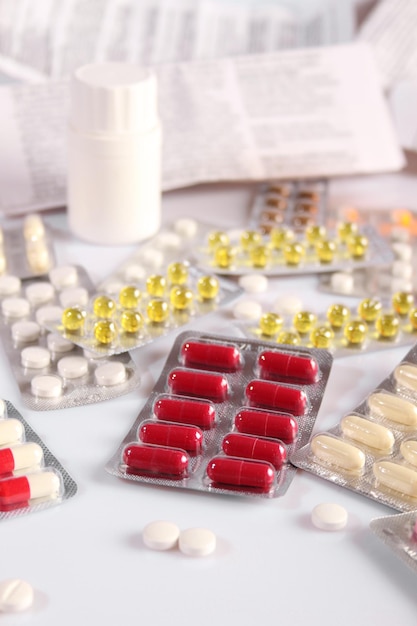 Molte pillole diverse e multicolori su un tavolo bianco gocce per naso e istruzioni assistenza sanitaria