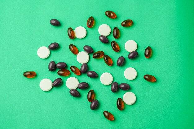 Many different tablet pills on color background, flat lay, with copy space.