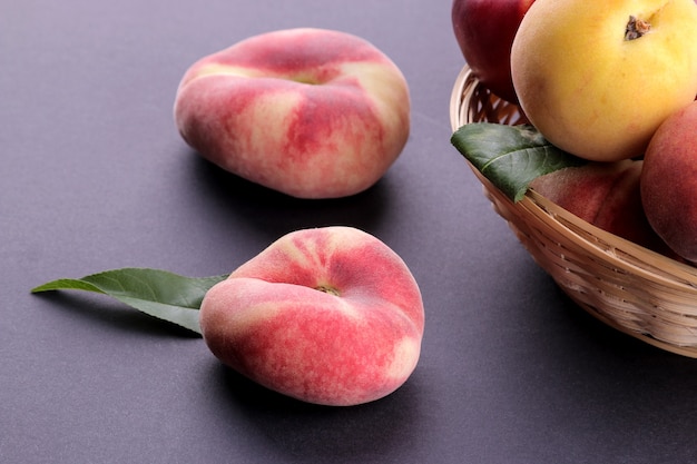 Many different varieties of peaches in a wicker basket