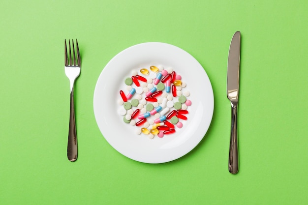 Many different weight loss pills and supplements as food on round plate Pills served as a healthy meal Drugs pharmacy medicine or medical healthycare concept