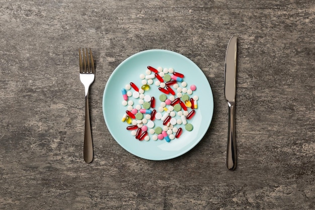 Many different weight loss pills and supplements as food on round plate Pills served as a healthy meal Drugs pharmacy medicine or medical healthycare concept