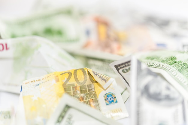 Many dollars and euro, leading currencies, close-up. Counterfeit american and european crumpled banknotes background. Finance and business concept.