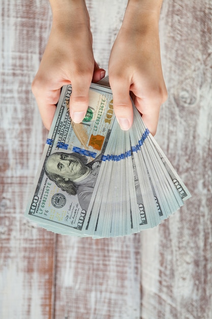 Many dollars falling on woman's hand with money