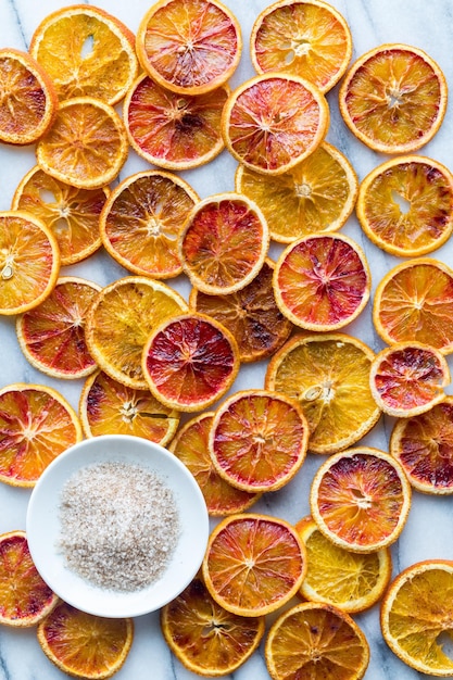 Foto molte fette di arance secche spruzzate di cannella e zucchero