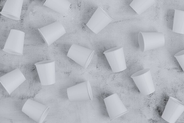 Photo many eco friendly paper cups placed on rough surface. sustainable concept. top view. minimalist style.