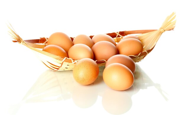 Много яиц в корзине, изолированные на белом фоне