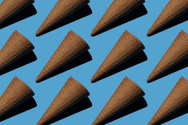 Many empty ice cream cones on a blue background