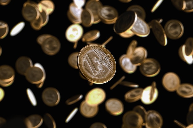 Molte monete in euro che cadono su uno sfondo nero isolato rendering 3d