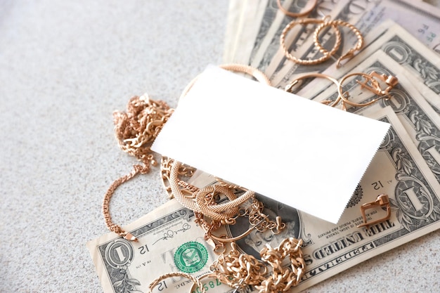 Molti costosi anelli di gioielli d'oro orecchini e collane con una grande quantità di banconote da un dollaro usa con spazio per la copia banco dei pegni o negozio di gioielli