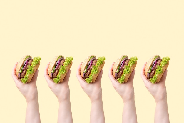 Photo many female hands with delicious burgers