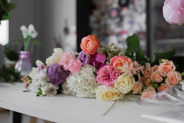 花屋アジサイのバラのスプレーローズのテーブルにはたくさんの花が横たわっています