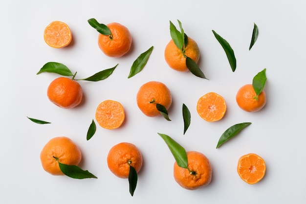 Many fresh ripe mandarin as colored background top view Elegant background of clementines and mandarin slices Top view flat lay