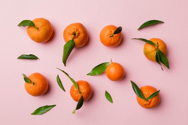 Many fresh ripe mandarin as colored background top view Elegant background of clementines and mandarin slices Top view flat lay