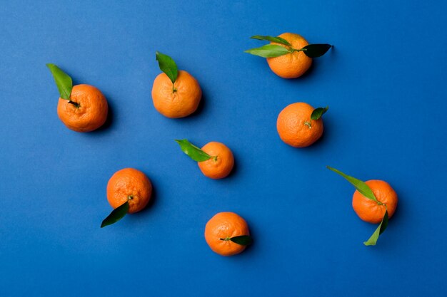 Many fresh ripe mandarin as colored background top view Elegant background of clementines and mandarin slices Top view flat lay